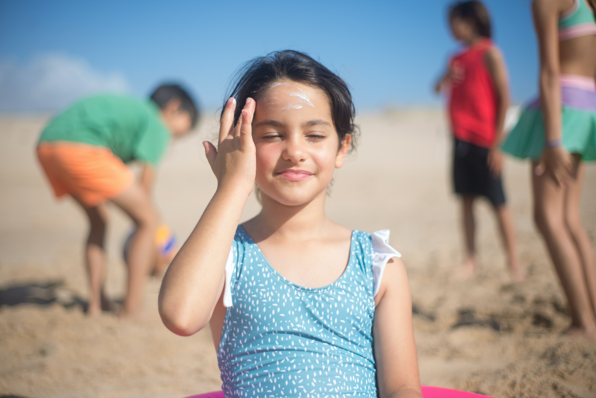 Girl at the beach putting sunscreen on face - Young Living Lavender Life Blog Canada 
