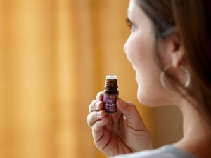 • Brown haired woman smelling a lavender oil bottle