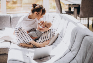 Mother holding baby on sofa