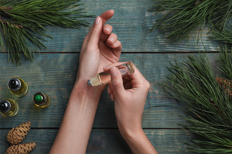 immagine di una donna che si applica l'olio essenziale sui polsi