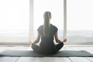 Žena meditira na prostirci za jogu