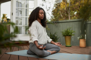 Moteris užsiimanti joga ir meditacija atviroje namų erdvėje