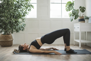 Vrouw in yogahouding op yogamat