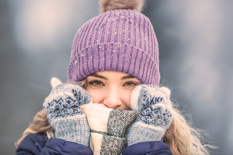 Blonde vrouw met hoed, sjaal en handschoenen