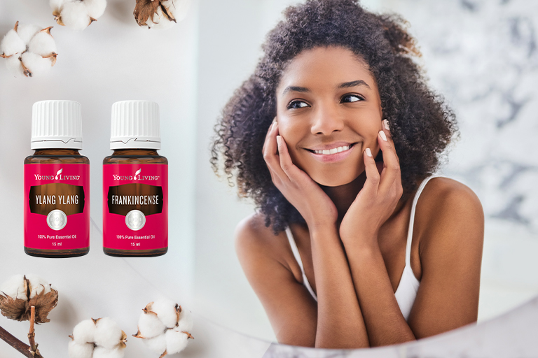 Ylang Ylang and Frankincense essential oils with smiling woman