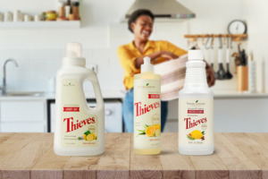 Le produit d’entretien Thieves® Household Cleaner, la lessive Thieves® Laundry Soap et le liquide vaisselle Thieves® Washing Up Liquid et une femme qui fait son nettoyage de printemps