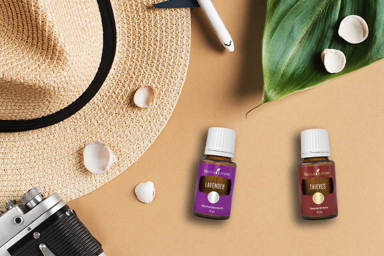 Les huiles essentielles Lavender et Thieves® avec un chapeau, des coquillages et une scène de vacances