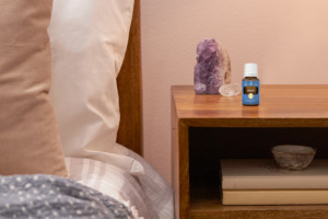 Awaken essential oil with crystal and books on bedside table