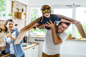 Vater, Mutter und Kind beim Spielen in der Küche und Young Living Logo