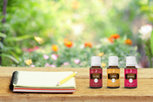 Les huiles essentielles d’arbre à thé, de citron et de patchouli avec un journal et une scène de jardin extérieur