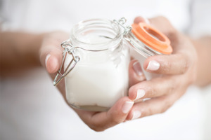 Jar of hair pomade held in woman’s hands