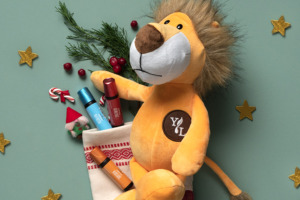 Imagem do conjunto "Natal com KidScents®" numa meia com o peluche Lex the Lion