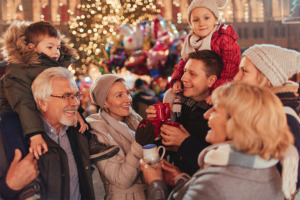 Glücklich aussehende Familie auf dem Weihnachtsmarkt in festlicher Atmosphäre