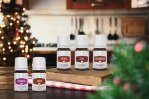 Ätherisches Zimtrindenöl, Gewürznelkenöl, Muskatnussöl, Ingweröl und Kardamomöl der Pluslinie von Young Living in weihnachtlicher Atmosphäre