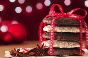 Ein Stapel Elisenlebkuchen festlich mit Schleife verpackt und mit Sternanis und Zimtstangen in weihnachtlicher Atmosphäre