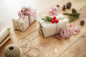 Bild på julklappar inslagna i brunt papper med snöre och rosett.