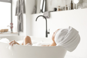 Afbeelding van een vrouw die geniet van een ontspannend bad.