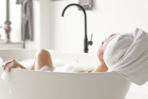 Frau in der Badewanne bei einem entspannenden Bad und ruhiger Atmosphäre