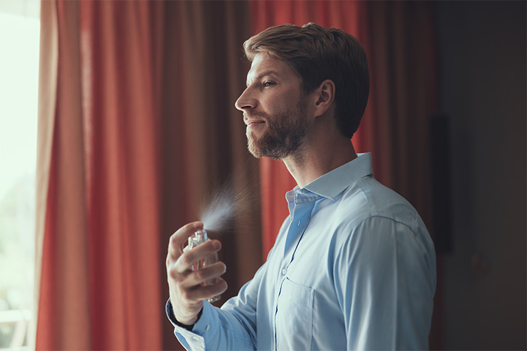 Afbeelding van een man die eau de cologne aanbrengt.