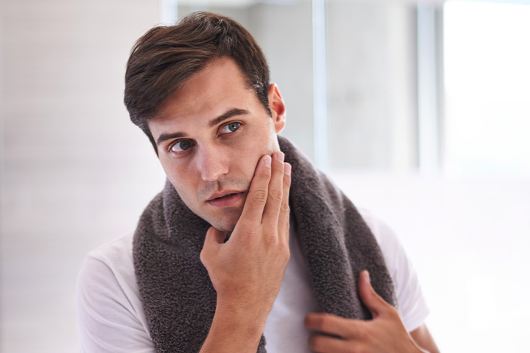 Image of man applying aftershave.