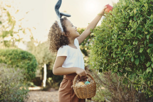 Image of little girl collecting Easter eggs in her basket.