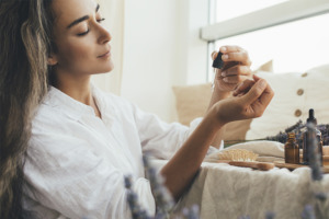 Image de femme appliquant un mélange d’huiles essentielles sur ses poignets.