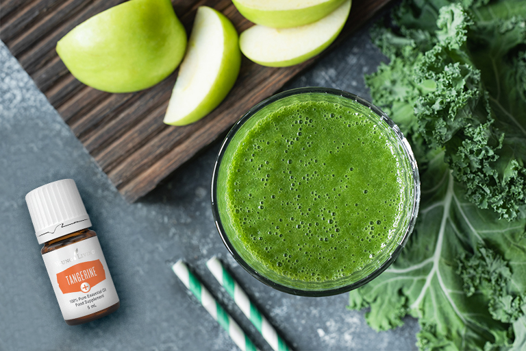 Image of green juice with kale, apples, and Tangerine+ essential oil.