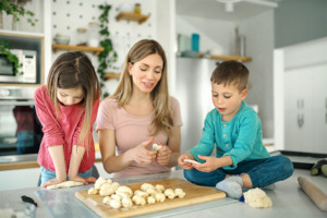 Mutter mit Kindern bei der Herstellung von Salzteig zum Basteln