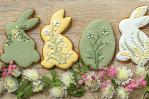 Verzierte Osterdekoration aus Salzteig in Häschen und Eier-Form mit Frühlingsblumen