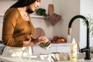 Image of woman cleaning dishes using Thieves® Washing Up Liquid.