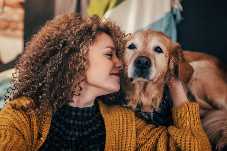 Imagem de uma dona a mimar o seu cão