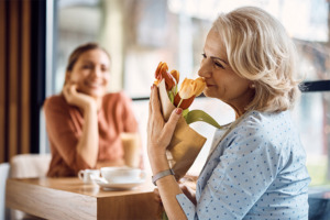 Mutter die an einem Strauß Tulpen riecht während ihre Tochter sie glücklich ansieht