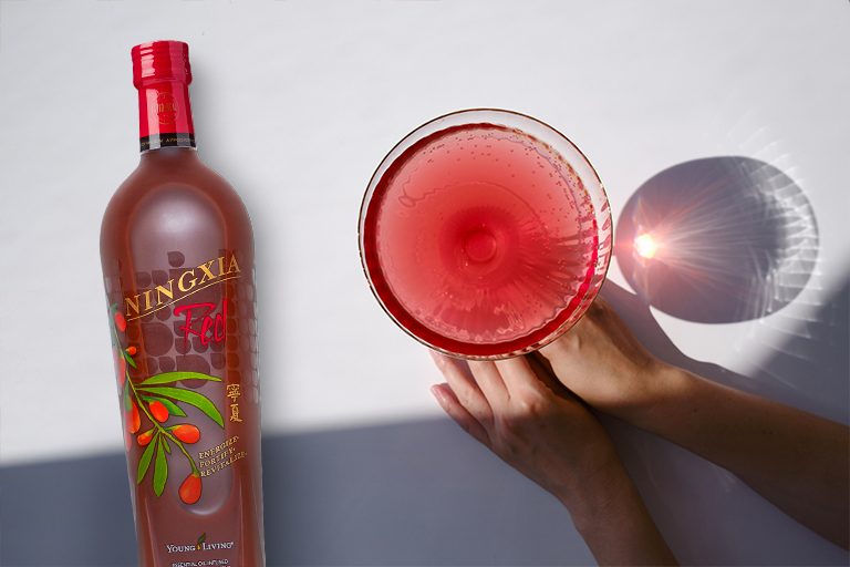 Egy pohár mocktail képe egy üveg NingXia Red® mellett.