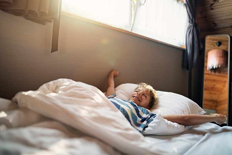 Image of a young boy waking up in the morning.