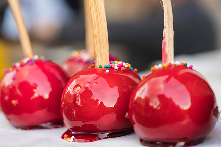 Image of candy apples lined up in row.