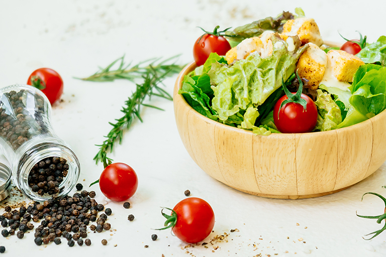    Image of a fresh salad with peppercorns.