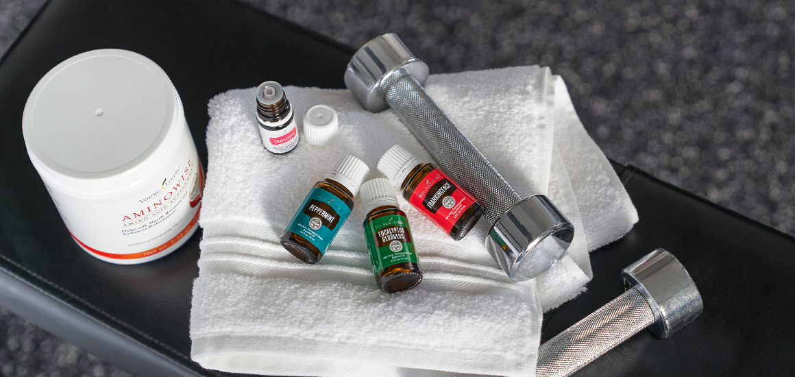Young Living essential oils and products next to a dumbbell and towel