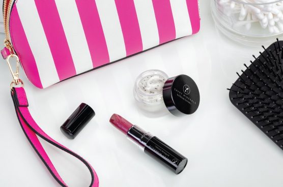 savvy minerals lip scrub and savvy minerals lipstick in a shade of pink with a pink and white striped cosmetic bag