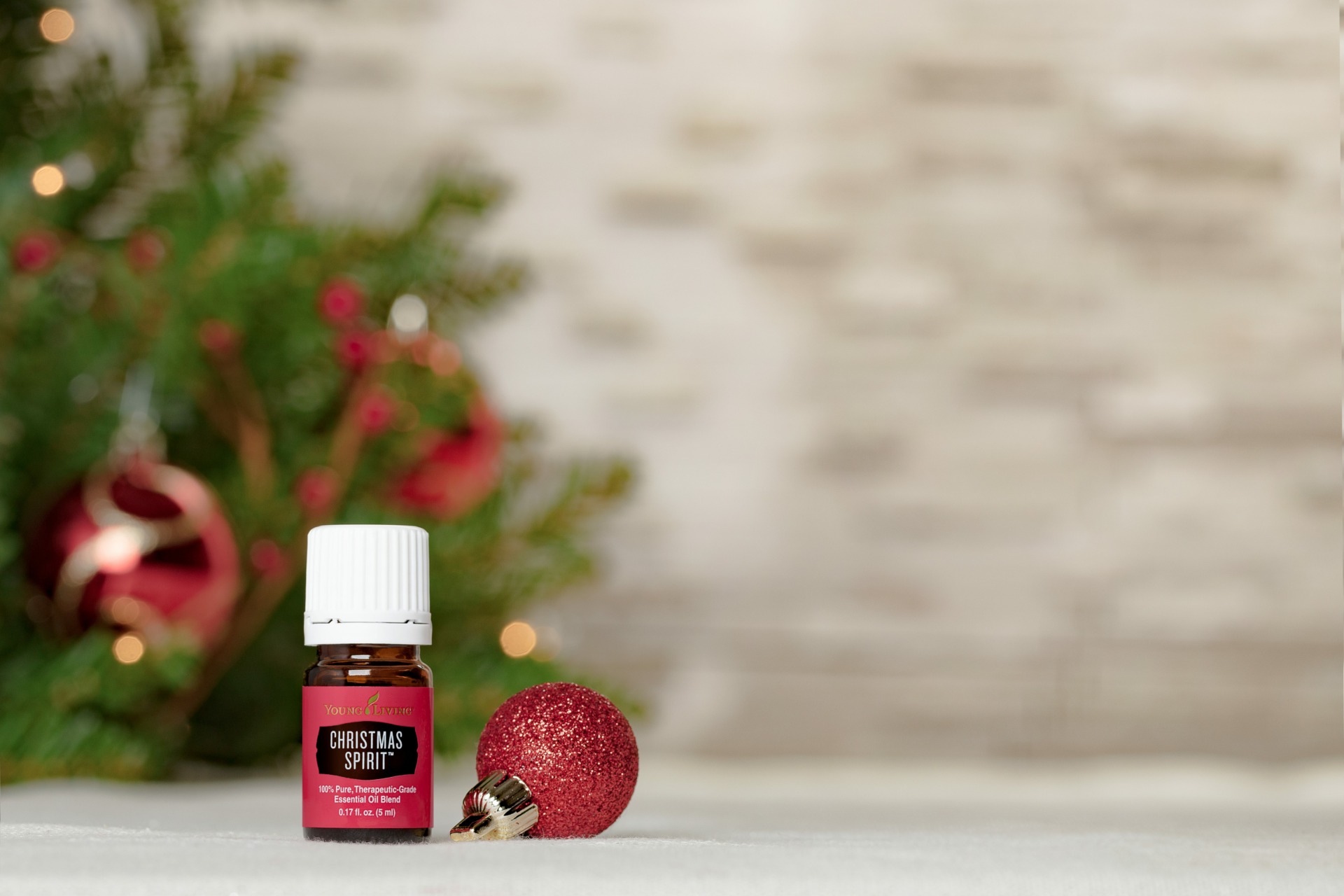 christmas spirit essential oil in front of a festive christmas tree