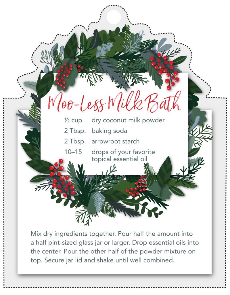 Moo-less milk bath printable gift tag showing a festive wreath and the recipe. Moo-less milk bath recipe: 1/2 cup dry coconut milk powder, 2 tablespoons baking soda, 2 tablespoons arrowroot starch, 10 to 15 drops of your favorite topical essential oils. mix dry ingredients together. pour half the amount into a half pint-sized glass jar or larger. drop essential oils into the center, pour the other half of the powder mixture on top. secure jar lid and shake until well combined. 