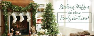 a festive living room with stocking stuffer ideas, decorated for christmas with a tree, stockings, and presents. Corner text says: "Stocking stuffers the whole family will love!"