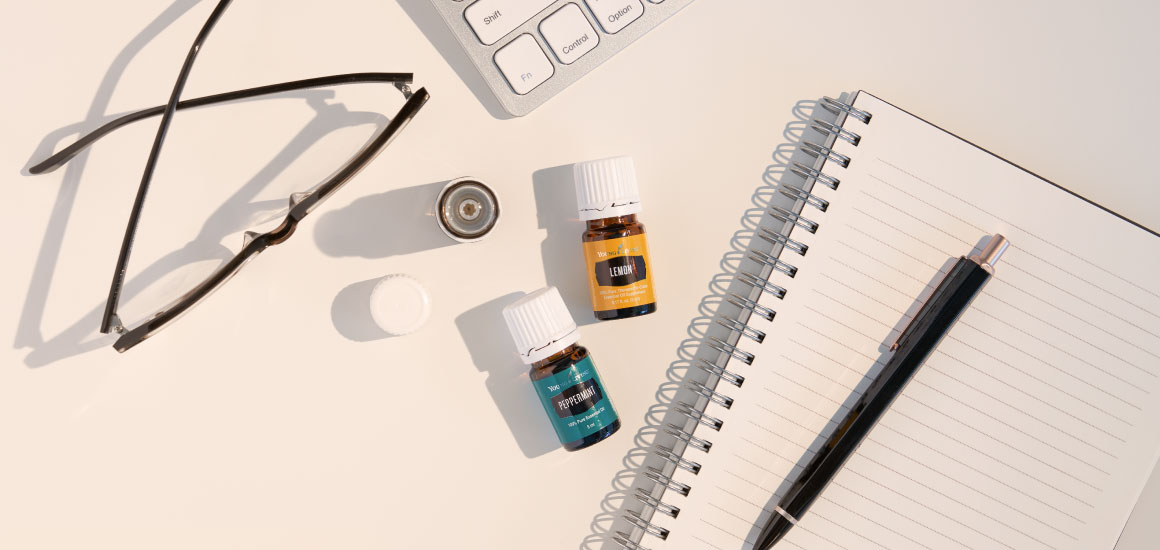 reading glasses, notebook, keyboard and peppermint and lemon essential oil for productivity