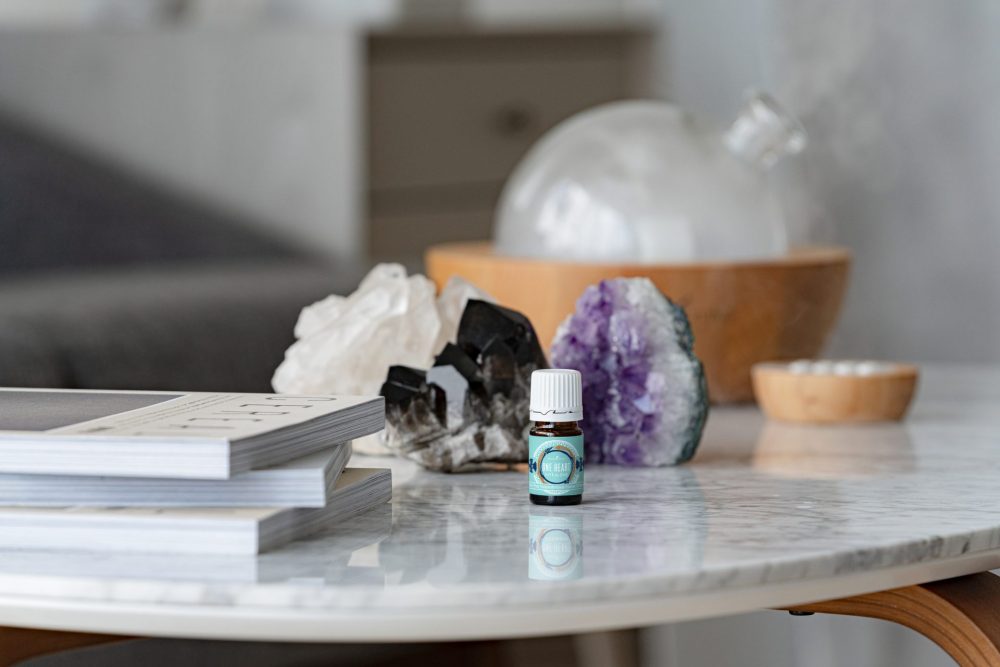 one heart essential oil blend on a table with crystals and a diffuser