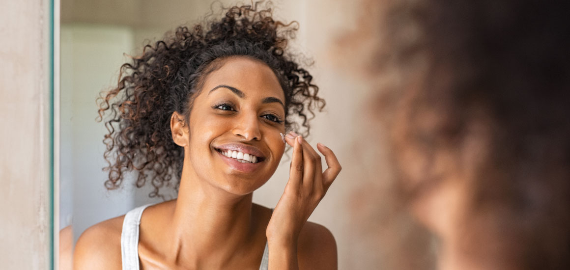 blog-Save-face–5-DIYs-for-your-skin-type-Convention-2020-Repost_Tile_US Woman applying Young Living BLOOM moisturizer to her face