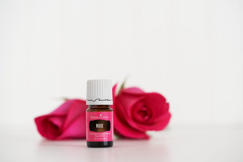 a bottle of rose essential oil by roses. learn the benefits of rose oil
