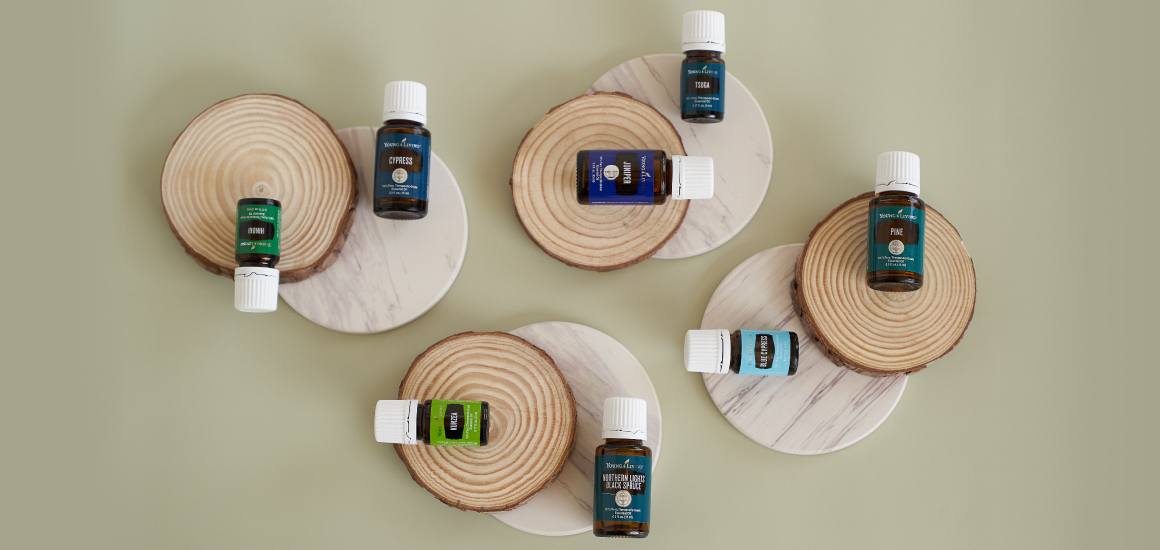 woodsy essential oils arranged on circles of wood and marble 