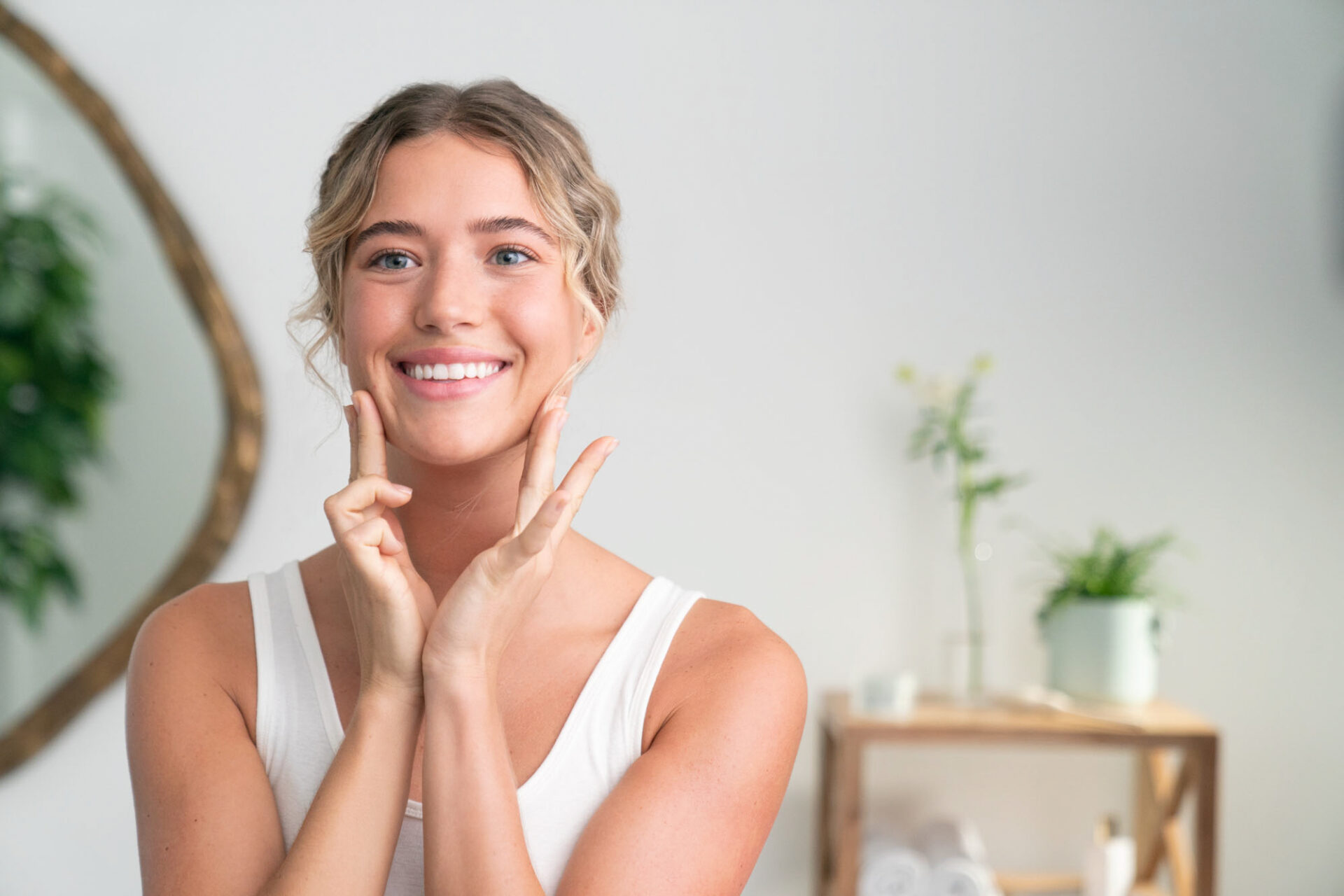 Woman smiling while putting on skin care - Young Living Lavender Life Blog 