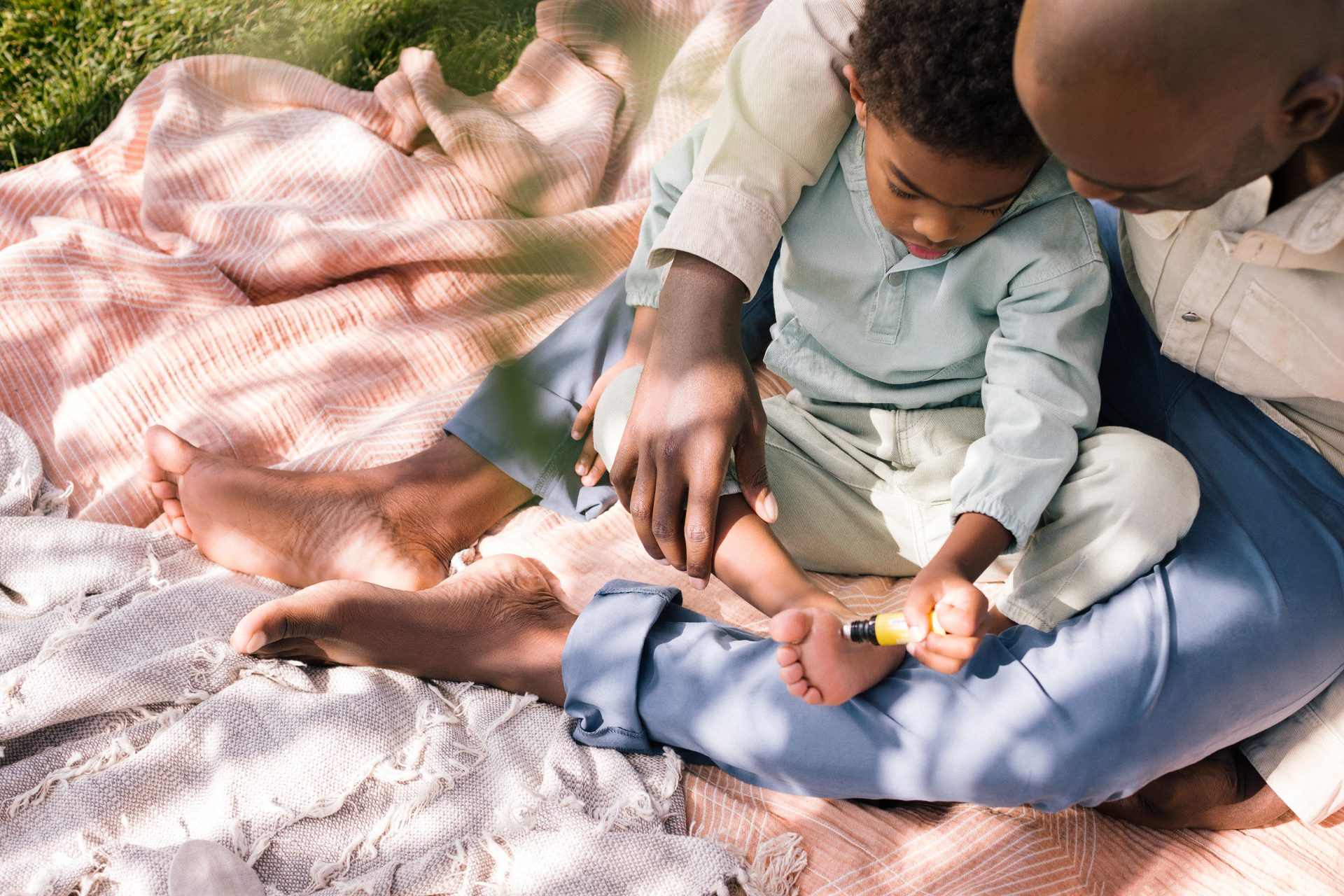 Dad helping apply Young Living essential oils to child's foot