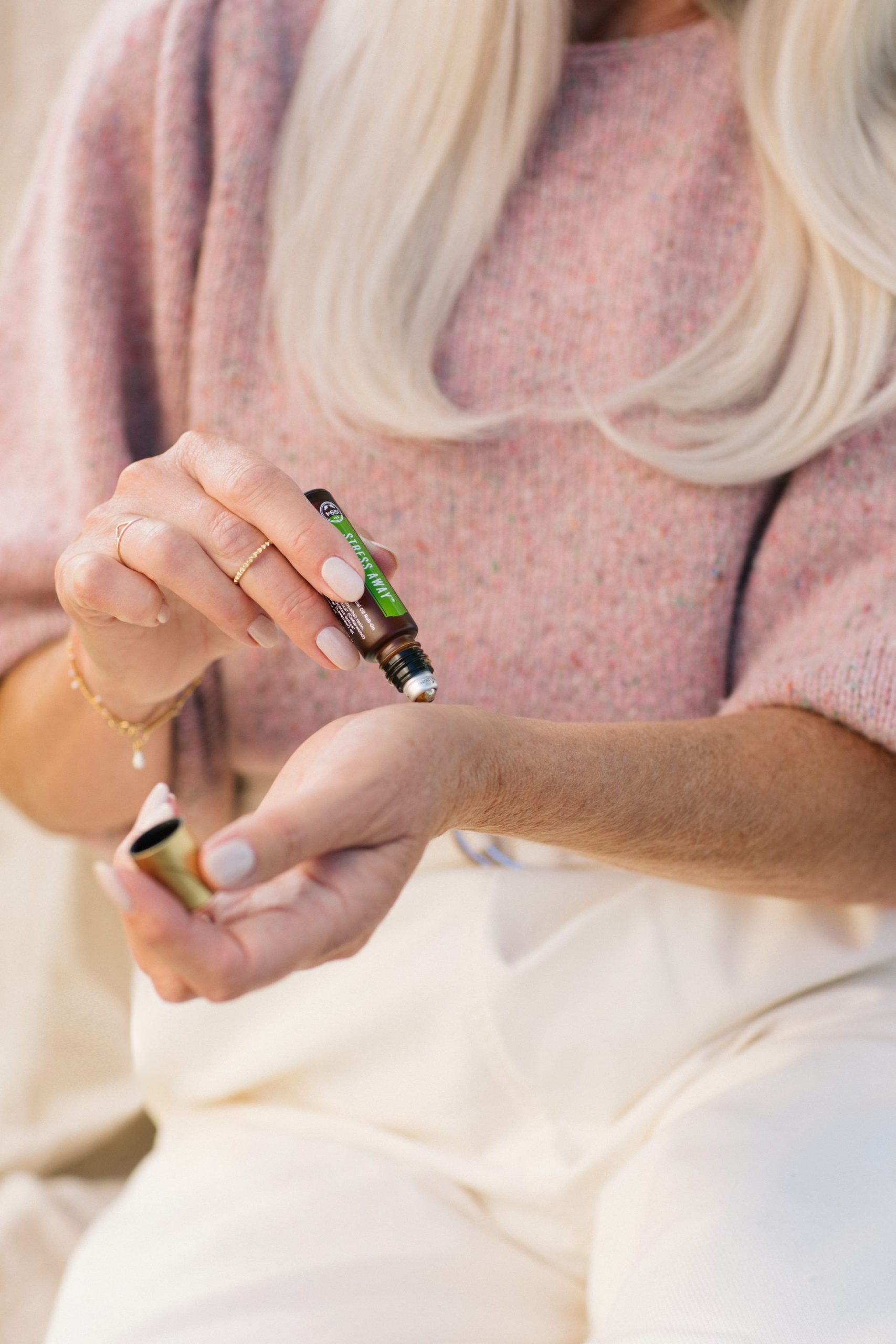 Woman applying Stress Away Roll-On--Young Living Essential Oils Blog 