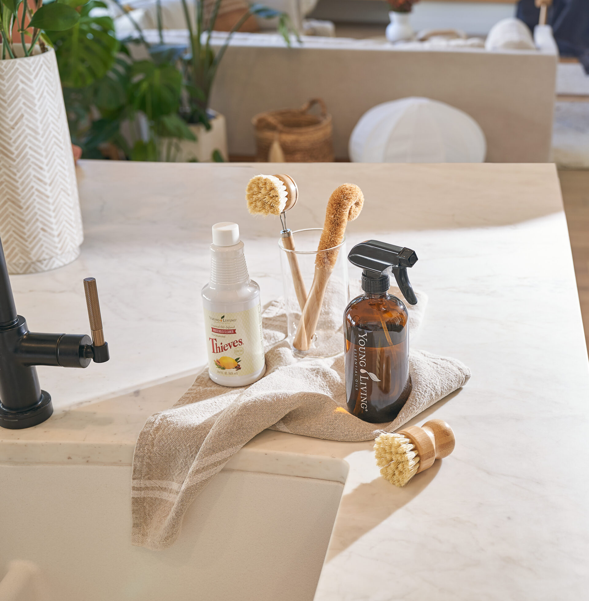 Thieves Household Cleaner, spray bottle, and scrub brushes on countertop - Young Living Lavender Life Blog 